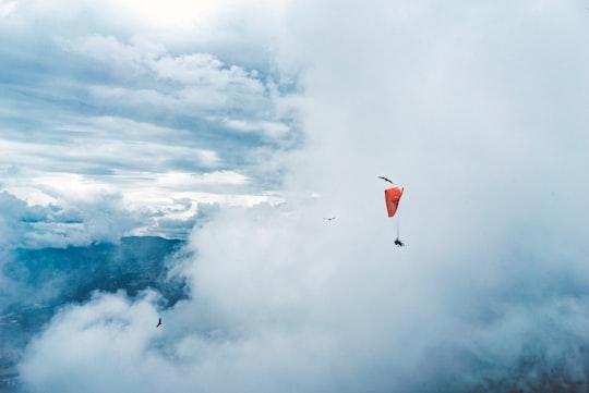 person paragliding surround by clouds in Medellín Colombia