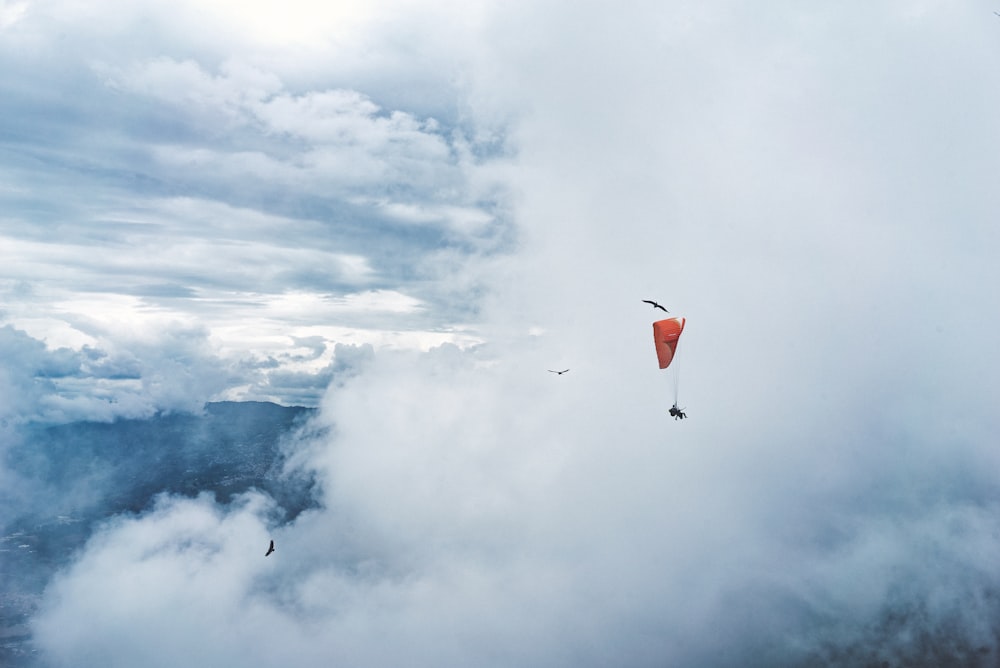 person paragliding surround by clouds