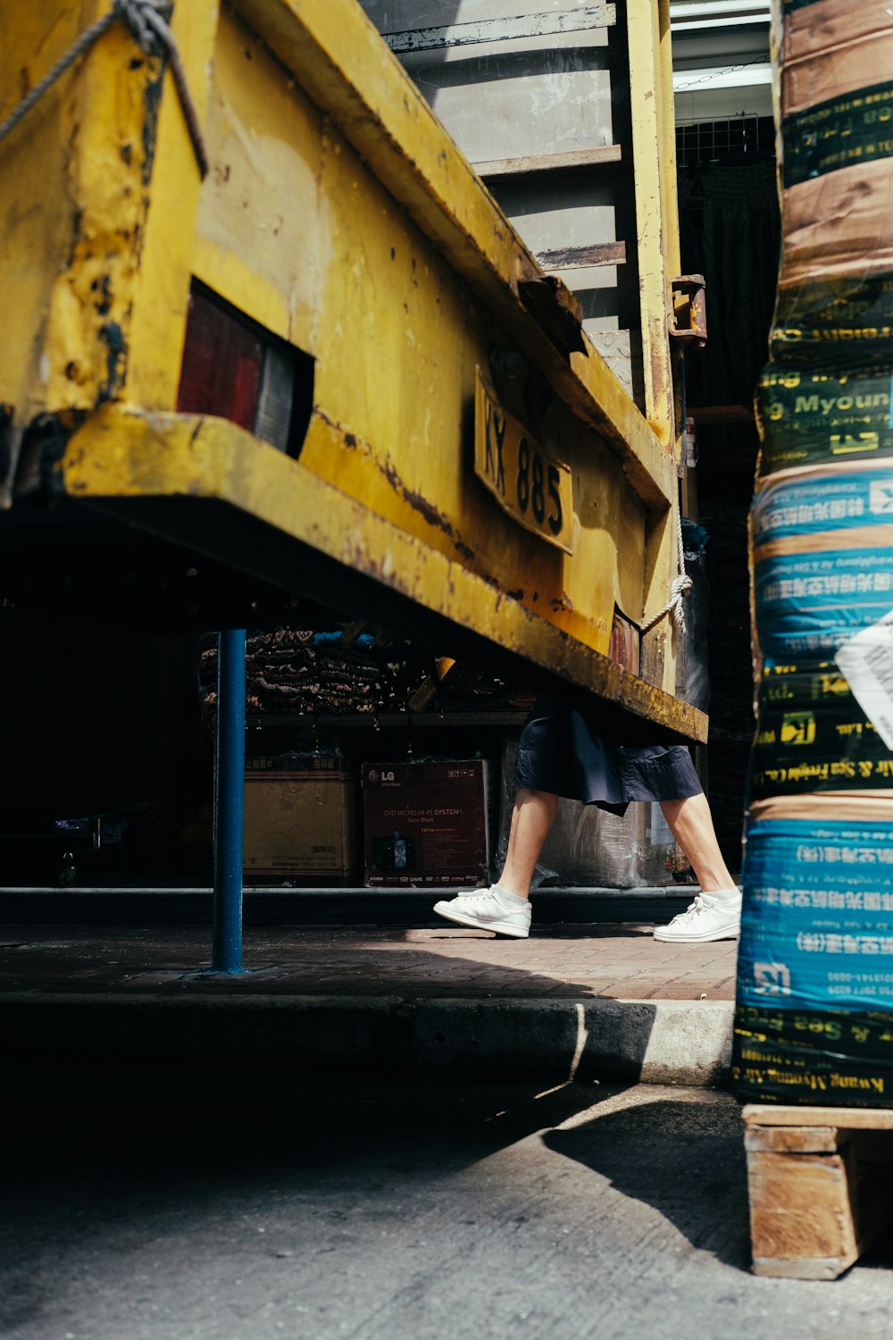 person walking beside yellow container