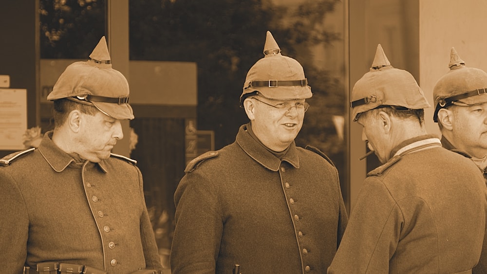 four men wearing caps