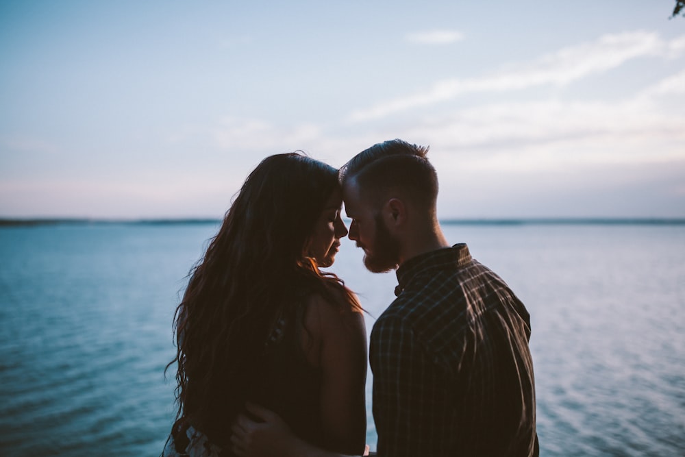 Hombre y mujer planeando besar a otro cerca del océano