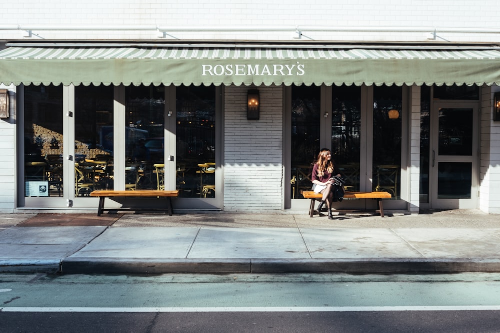 woman sitting in front of the store