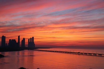 silhouette of buildings near body of water during dawn panama zoom background