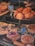 A variety of baked goods are displayed in a bakery window, including loaves of bread, pastries, and desserts. There are neatly arranged gougères, layered cakes topped with raspberries, and fruit tarts.