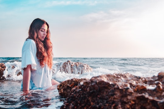 woman sitting at the rocky shore in Batroun Lebanon