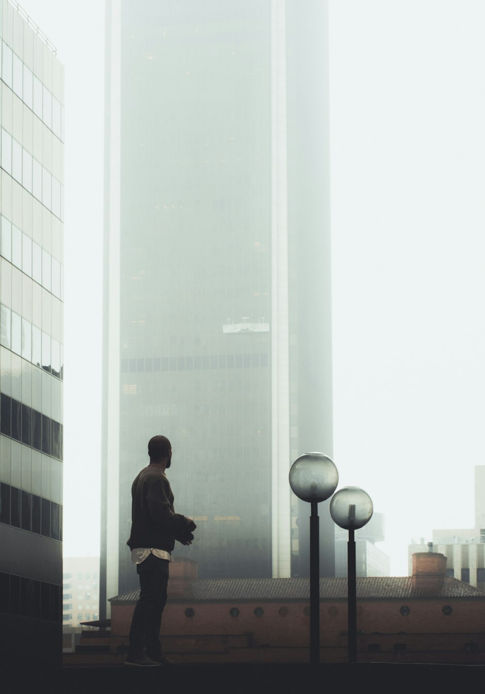 man standing near glass building during daytime