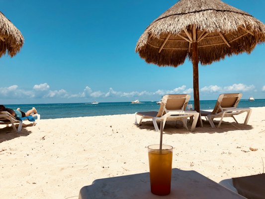 Brown parasol and two beach chairs on beach sand — Cozumel, Mexico