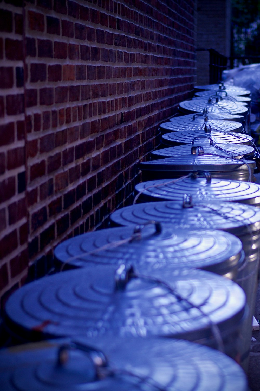 stainless steel trash bins beside concrete brick wall