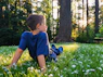 boy in blue t-shirt and blue shorts sitting on green grass field