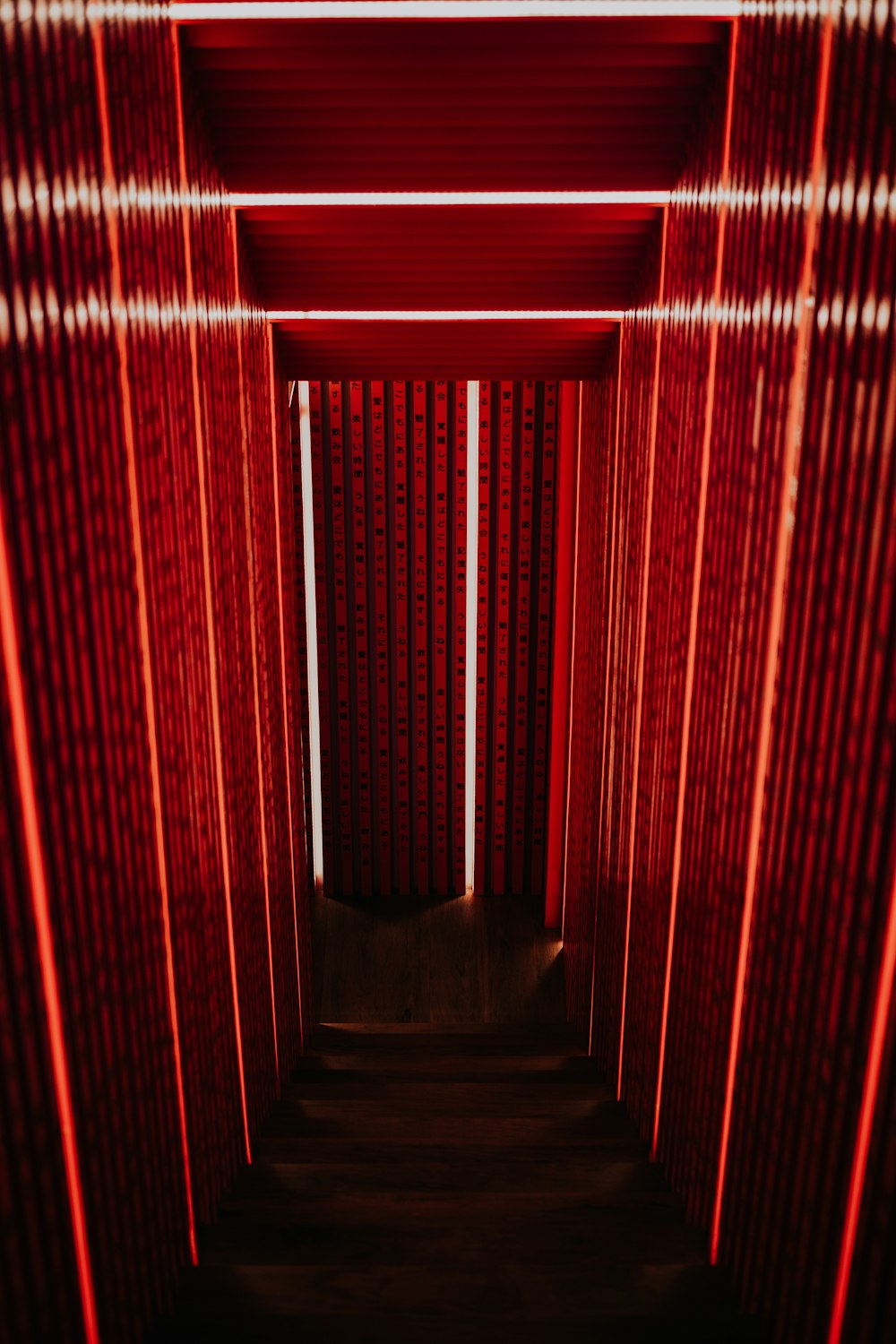 Escalera estrecha gris con pared roja