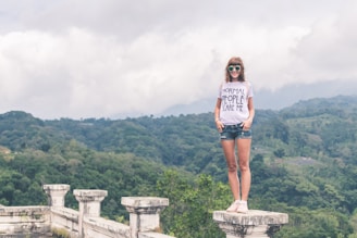 woman standing on concrete pillar