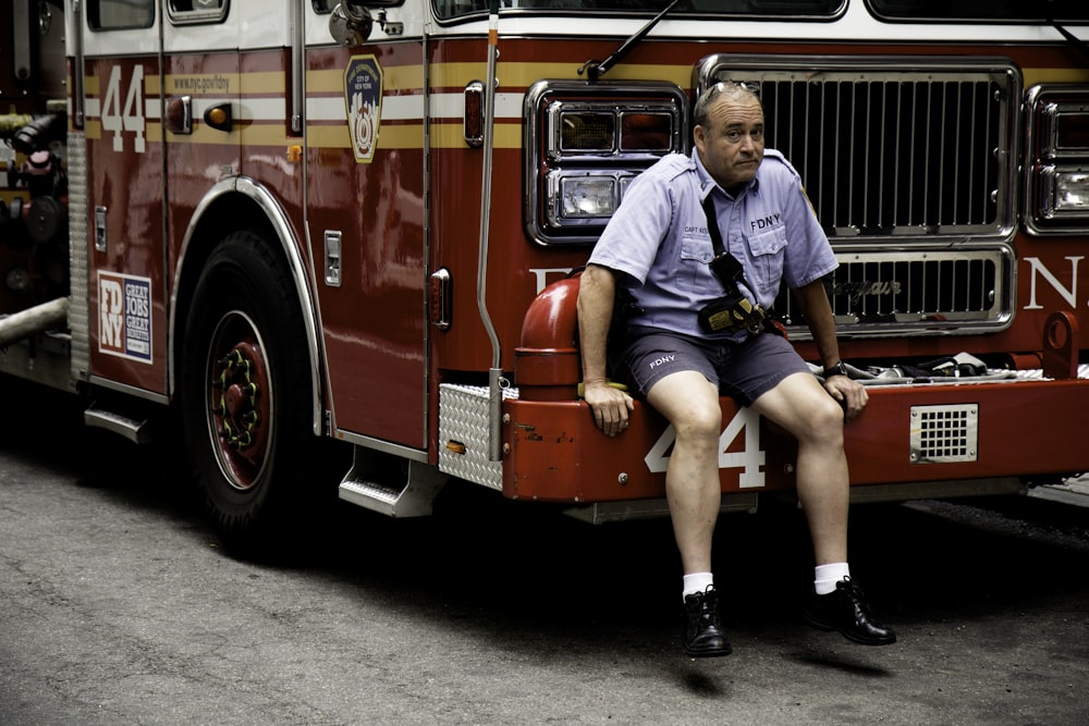 man sitting on vehicle bumper