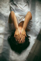a woman holds her hands over her face