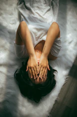 a woman holds her hands over her face