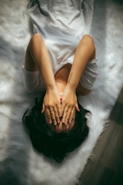 a woman holds her hands over her face