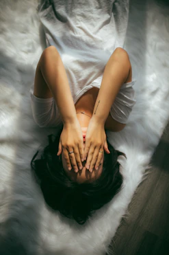 a woman holds her hands over her face