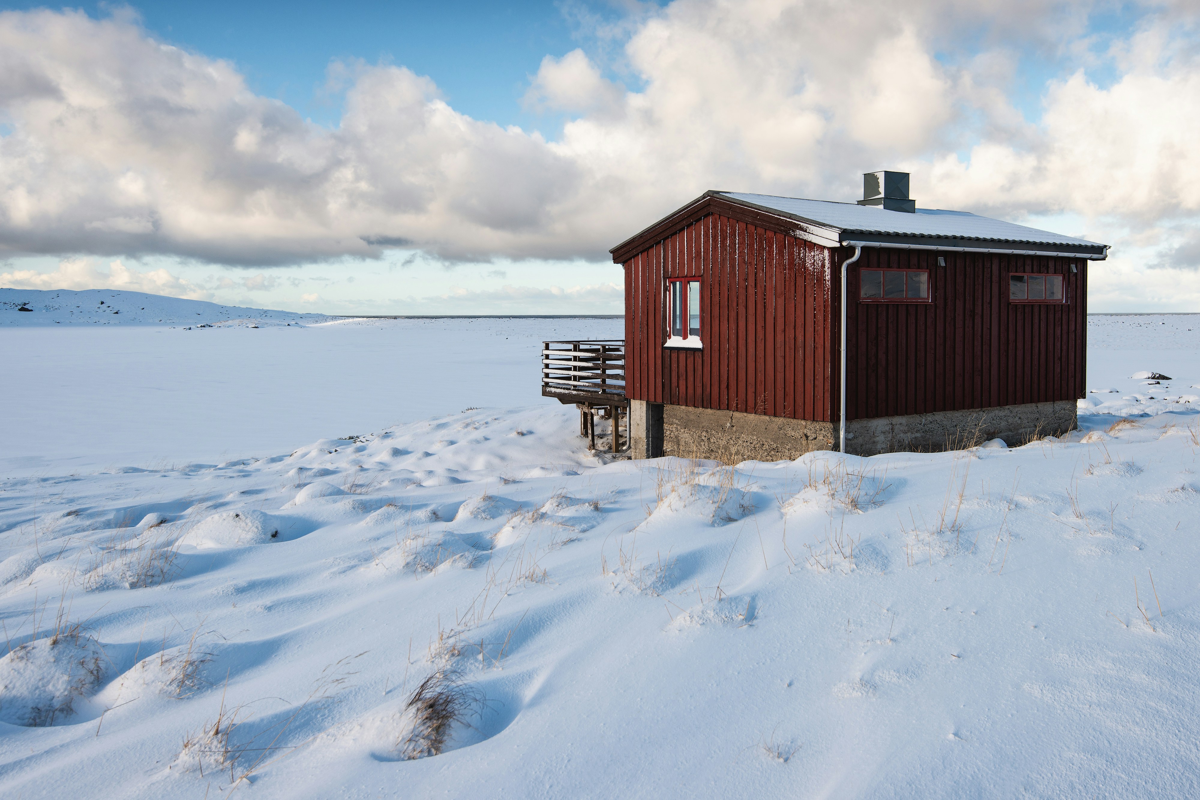 red and brown wooden cabin on field covered by snow at daytime, After a 30 minutes snowstorm, literally snow storm, the day turned clear, windy and much warmer.</p><p>During the snowstorm, I did not see any red house, to tell the truth you could not see anything that was more than 10 meters from your eyes, and then suddenly it appeared magically, like the sun and its blue sky.</p><p>So, I decided to start towards that red dot that I saw from afar, to better observe this little house in the middle of the absolute nothingness.