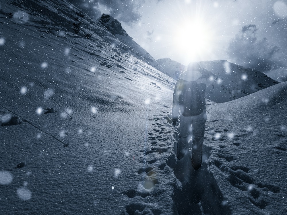 Person, die tagsüber auf schneebedecktem Feld spazieren geht