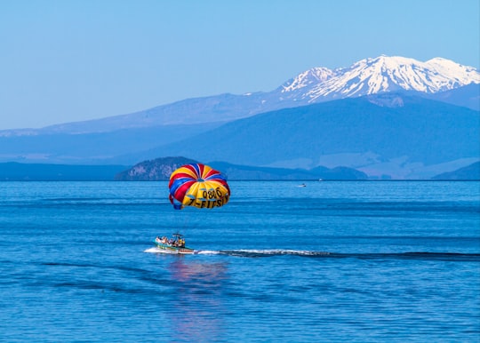 person riding a boat under blue sky in Lake Taupo New Zealand