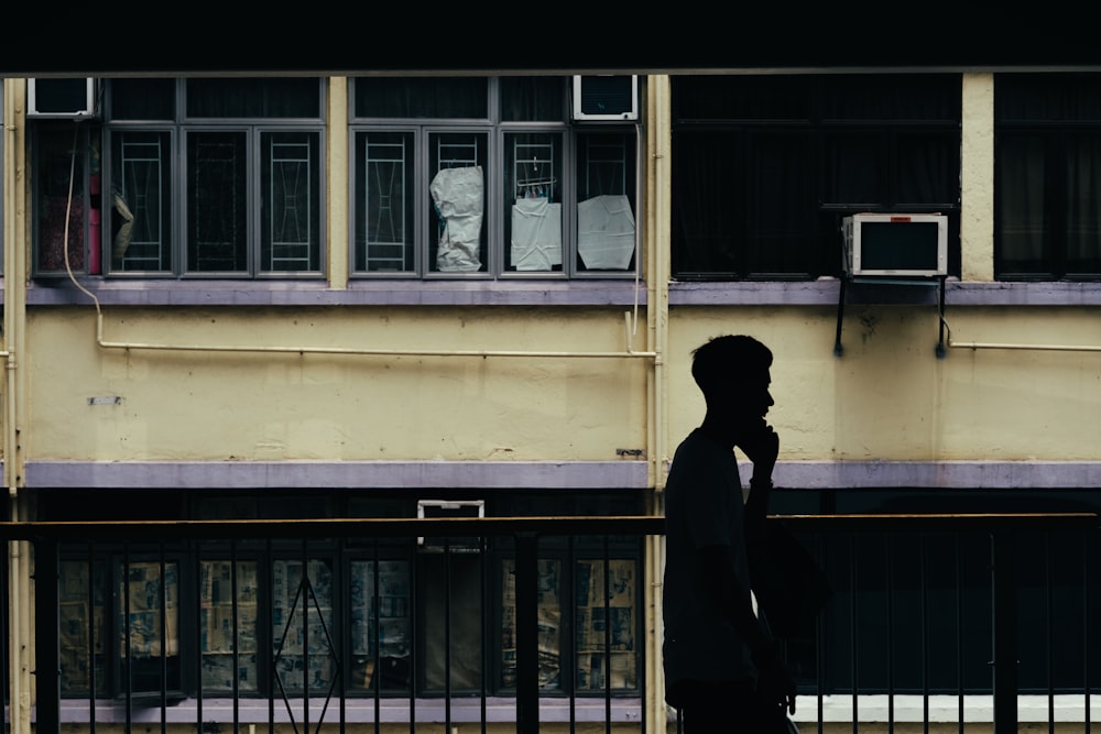 man standing by rail in building