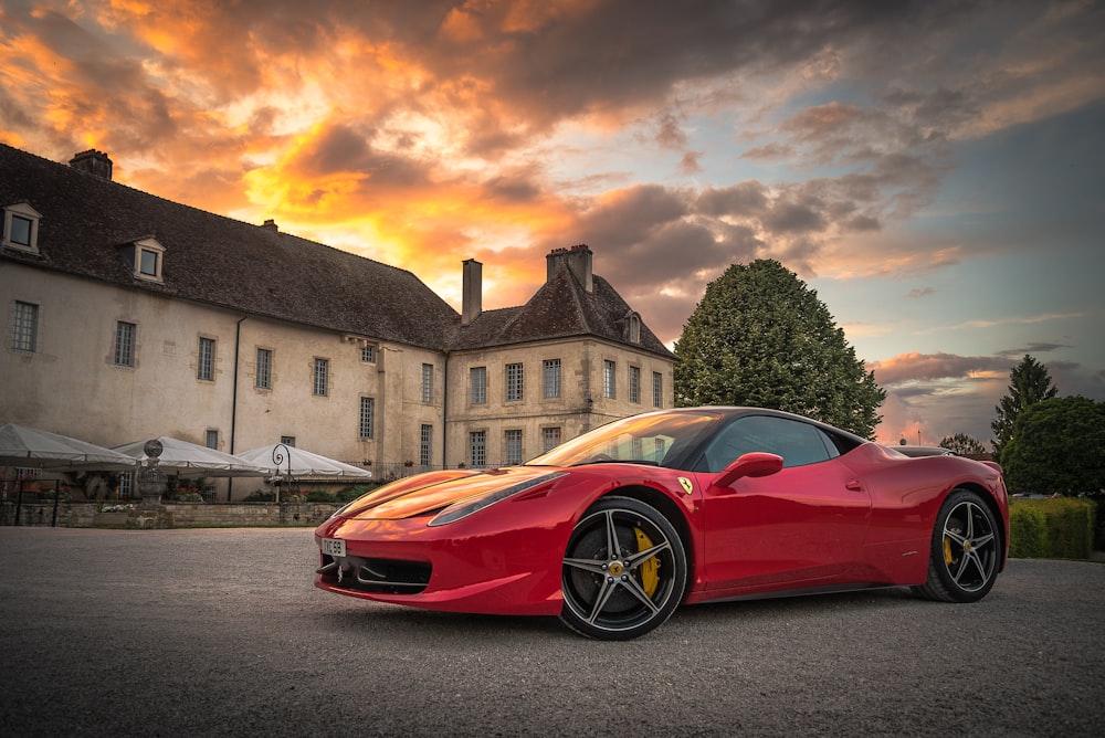 red sports car on gray surface near building