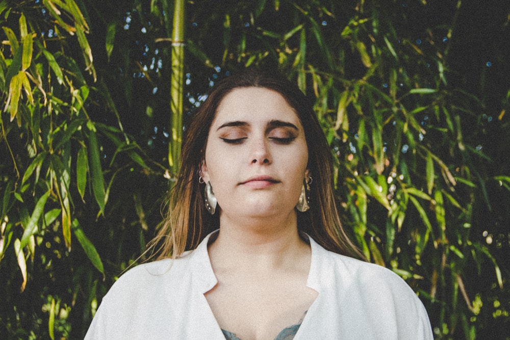 woman in white top near green trees during daytime