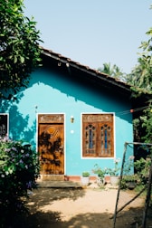 a blue house with two wooden doors and windows