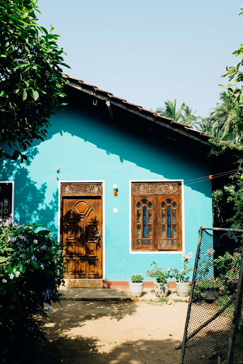 a blue house with two wooden doors and windows