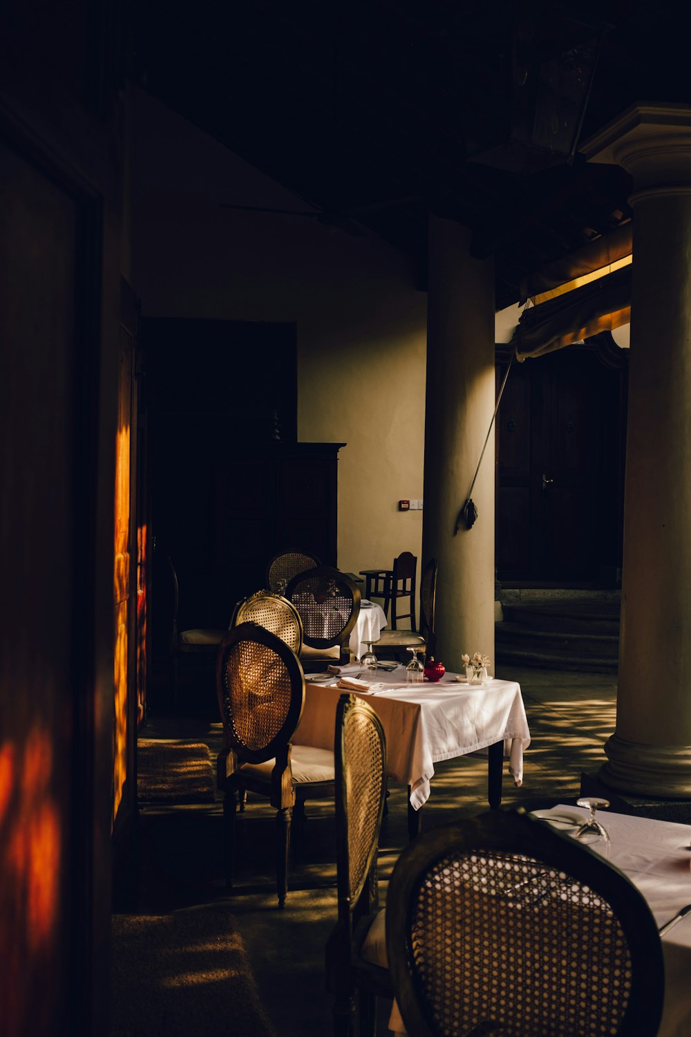 empty dining table with chairs near pillar