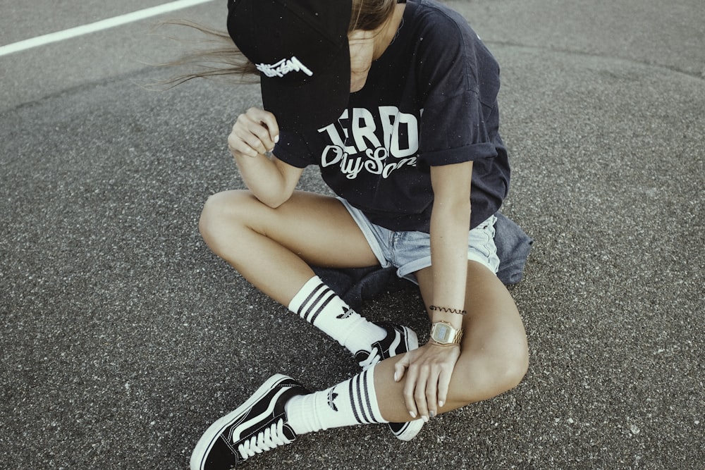 woman wearing black and white crew-neck shirt and gray shorts on gray concrete ground