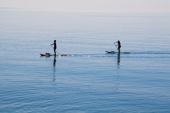 people ridding paddleboard on body of water in West Bay United Kingdom