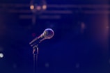 Close-up of microphone setup on stage with colorful lighting
