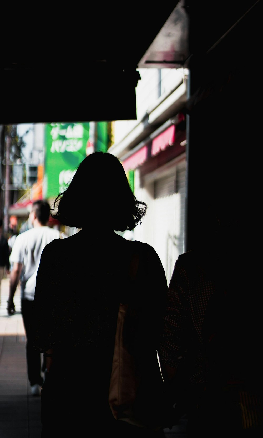 uma silhueta de uma mulher andando por uma rua