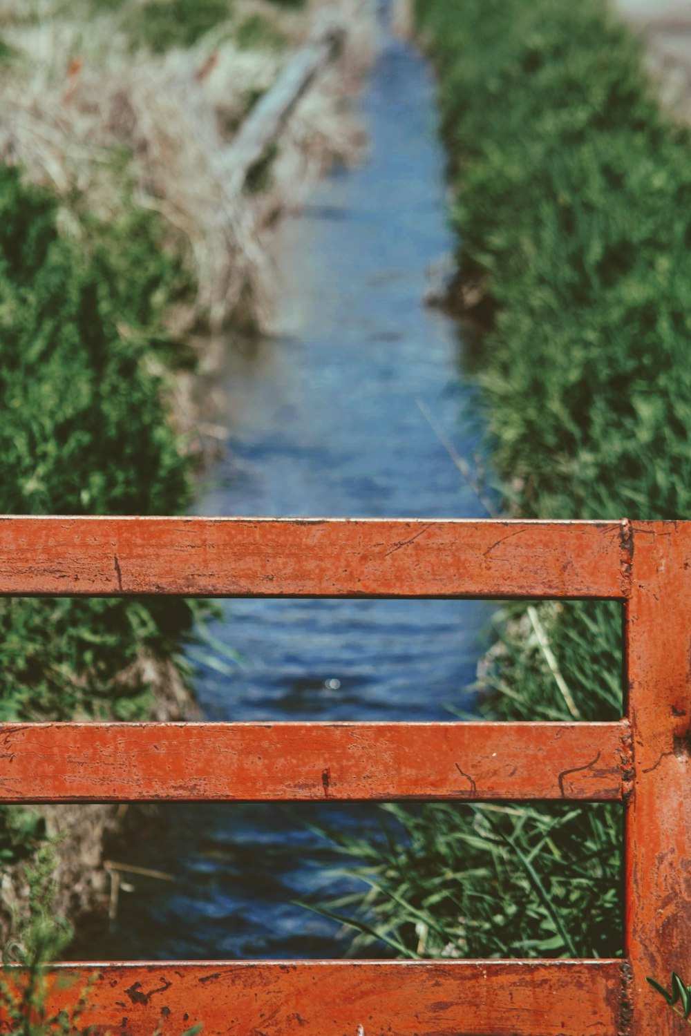 a wooden bench sitting next to a stream of water