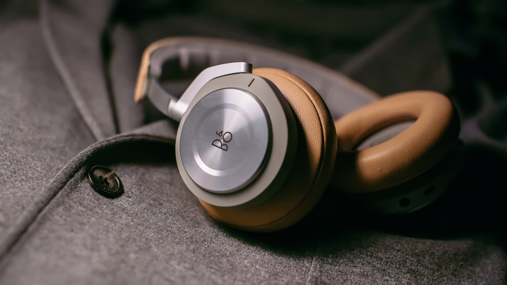 closeup photo of gray corded headphones on gray fabric sheet