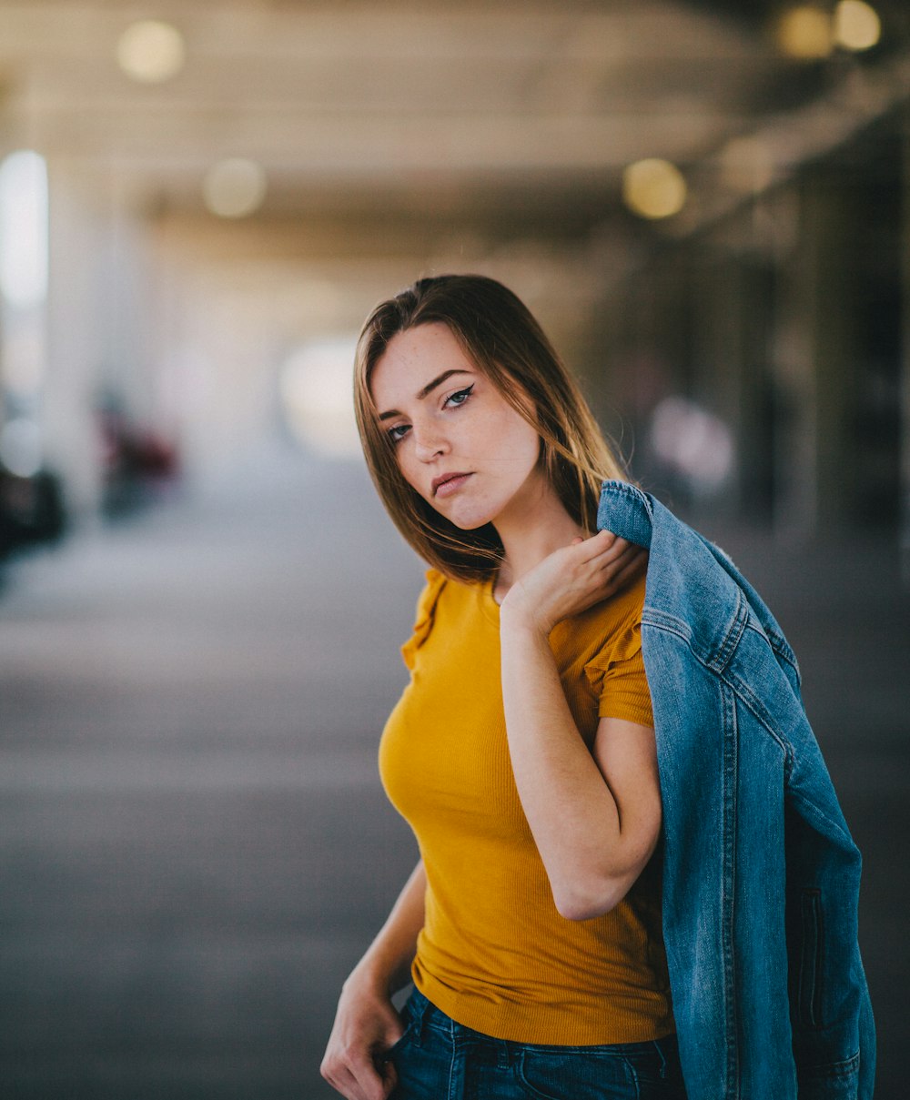 selective focus photography of woman holding blue denim jacket