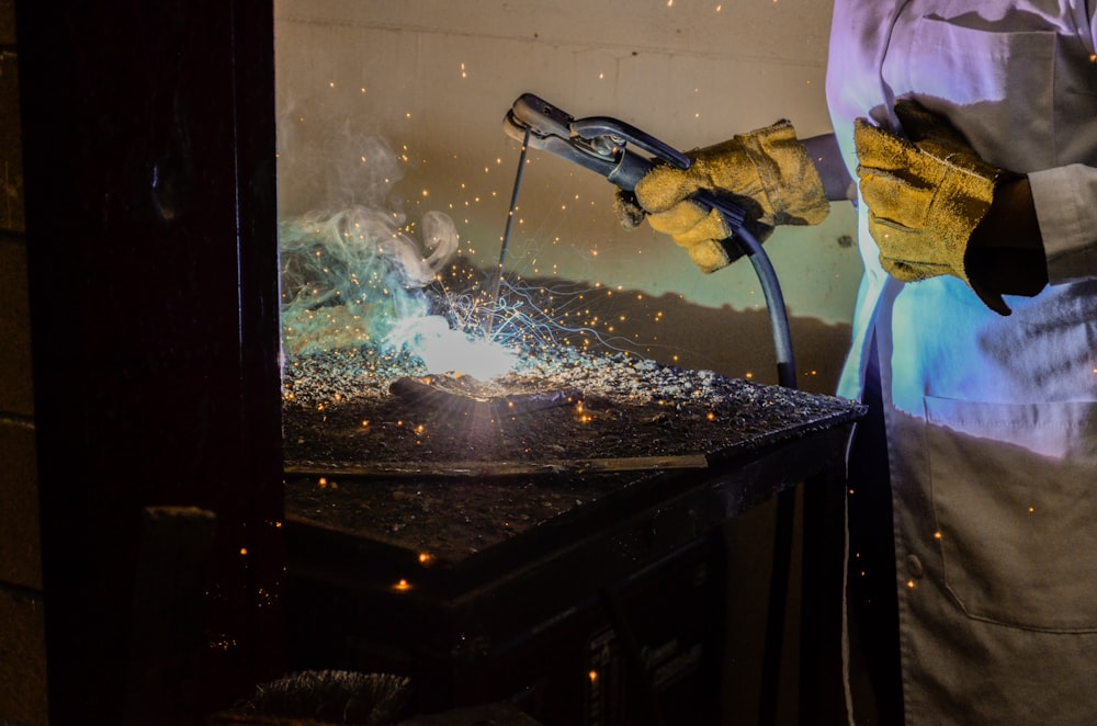 person welding metal using electrode holder