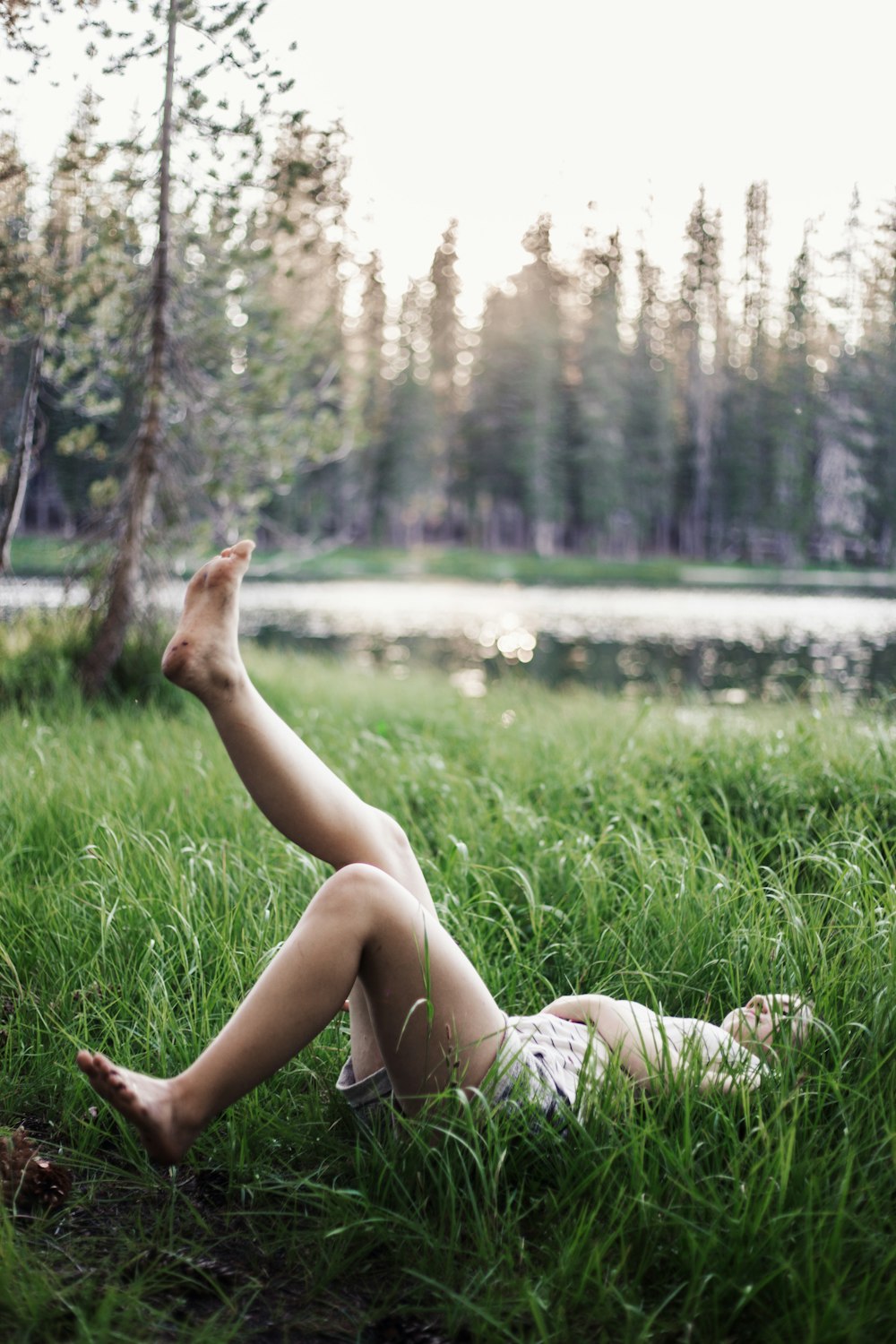girl laying on green grass field