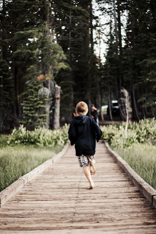Children running barefoot through the lush grass beside the market garden.