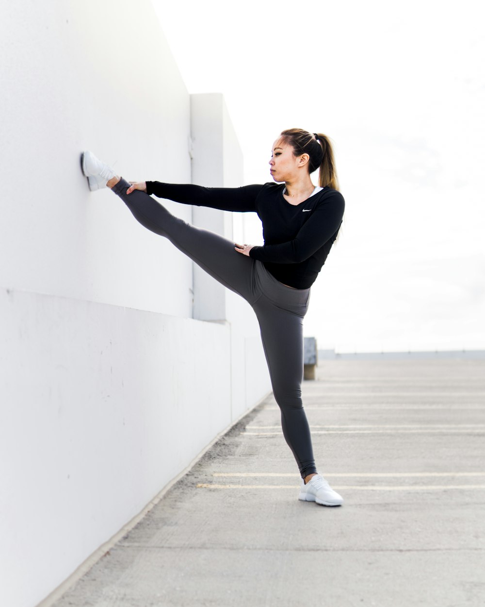 woman stretching on white wall