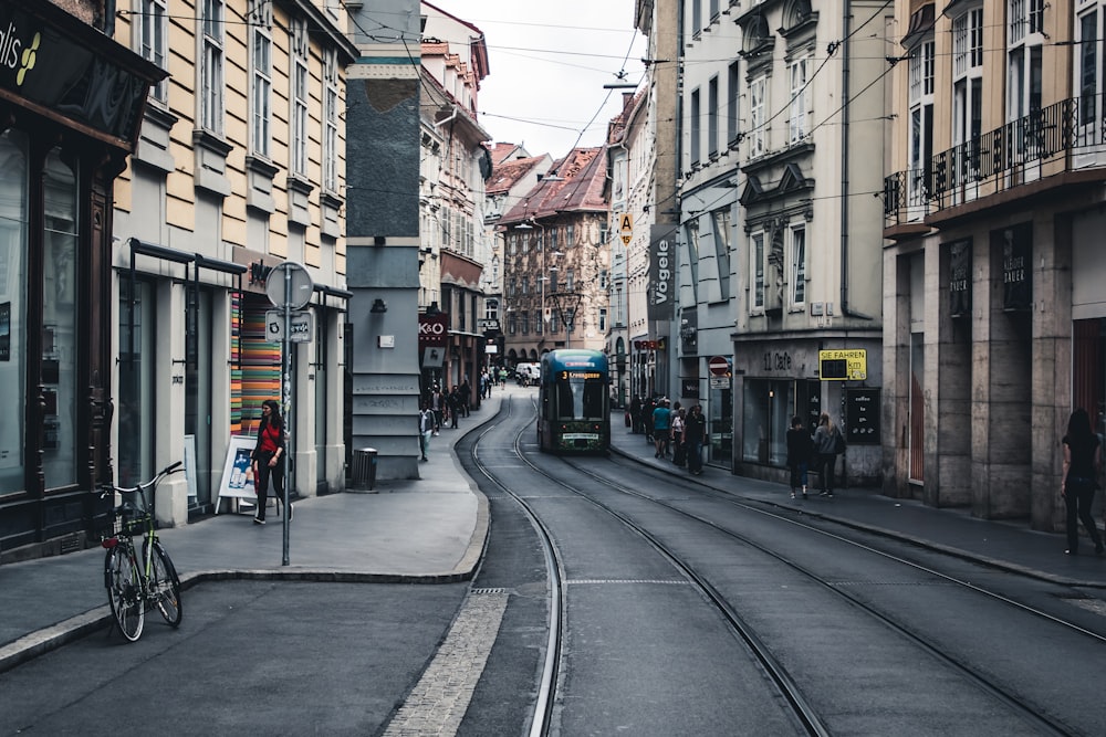 a narrow city street with a train on the tracks