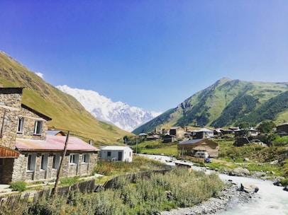 A peaceful Albanian village landscape with traditional stone houses under a clear blue sky.