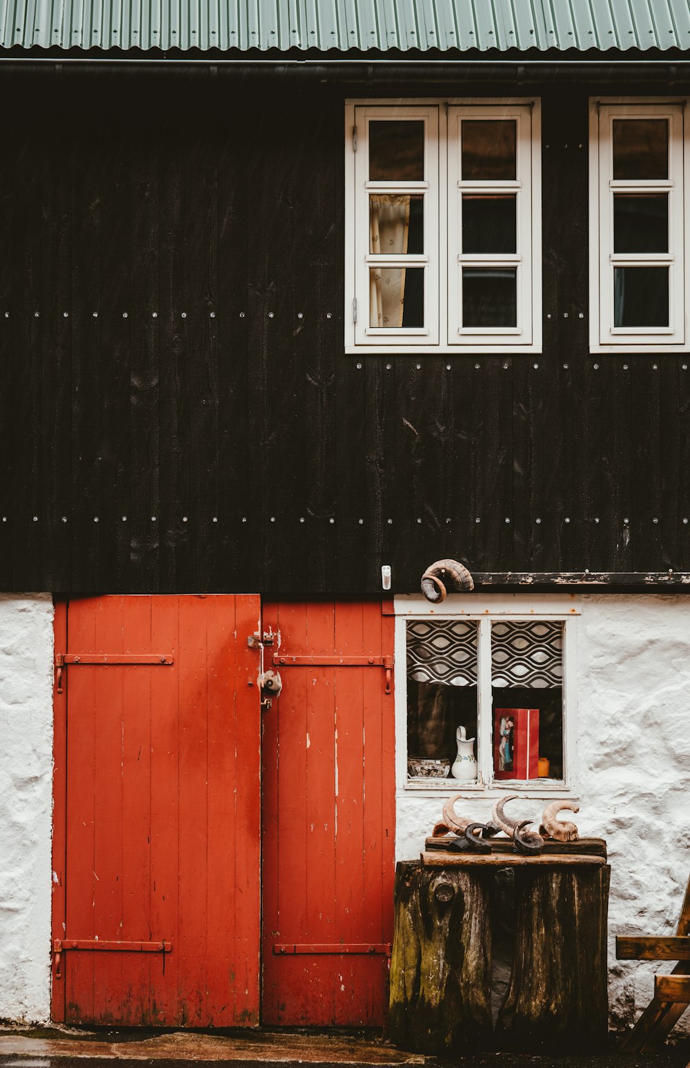 black and white house with red wooden door