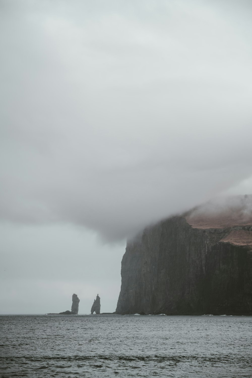 brown boulder under white cloud