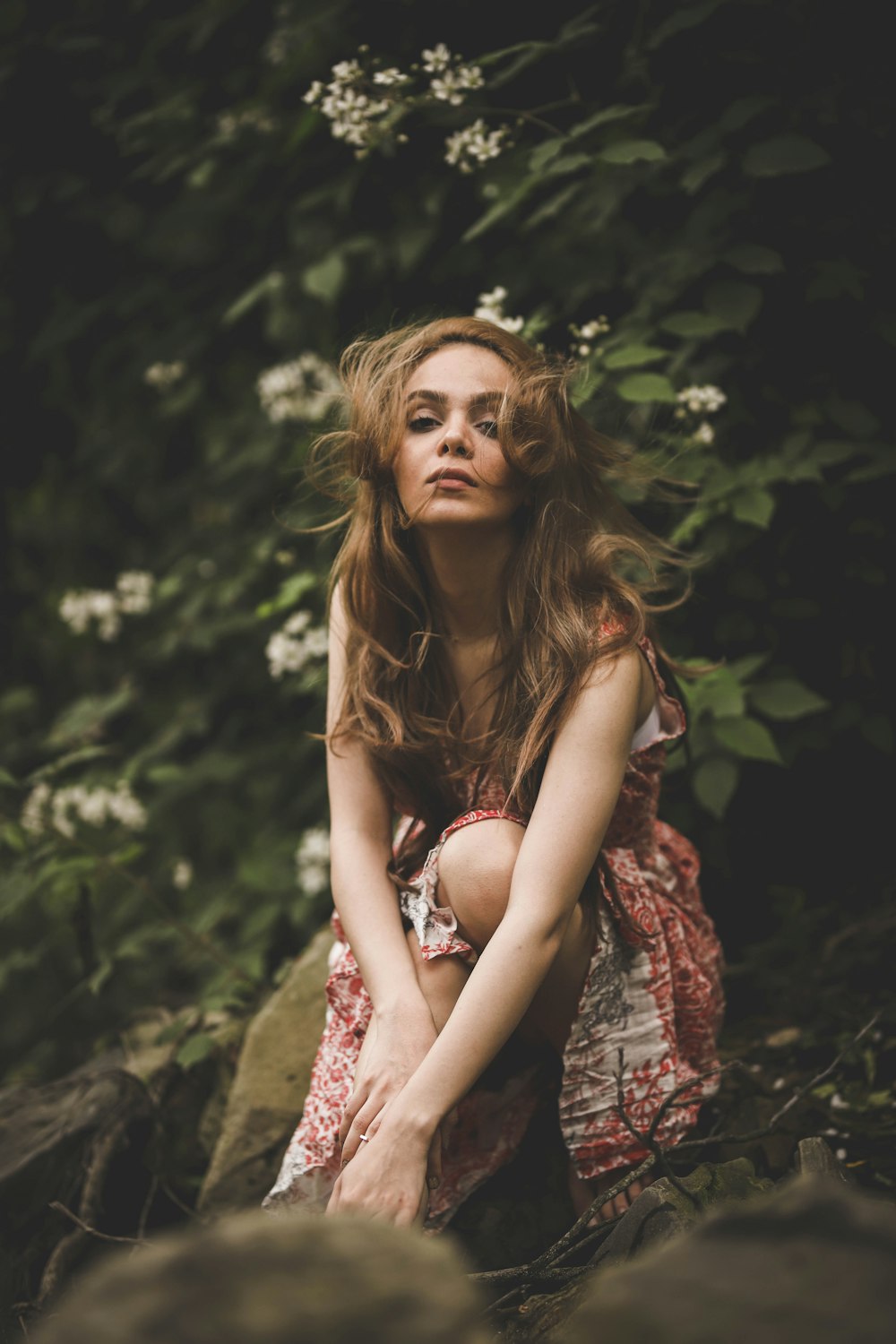 femme faisant la pose entourée de fleurs