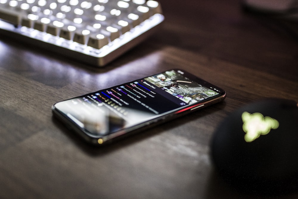 closeup photo of turned on smartphone near keyboard