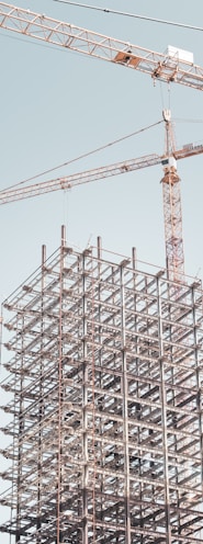 gray metal building frame near tower crane during daytime