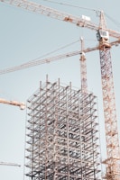 gray metal building frame near tower crane during daytime