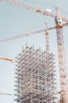 gray metal building frame near tower crane during daytime
