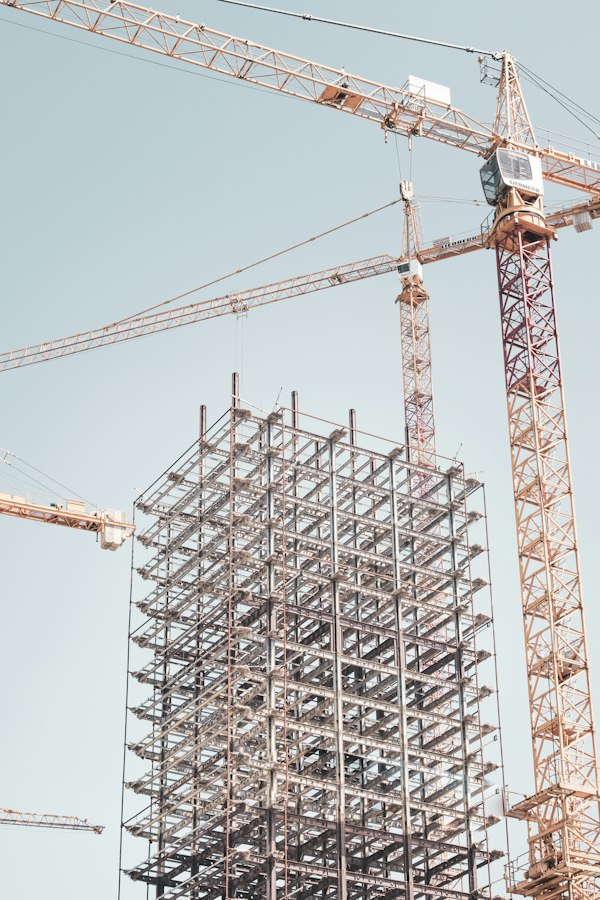 Estructura metálica en obra junto a una grúa torre, terreno del marketing para empresas de construcción industrial